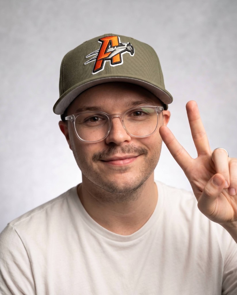 Jacob Olenick wearing an Athletics cap and making a peace sign